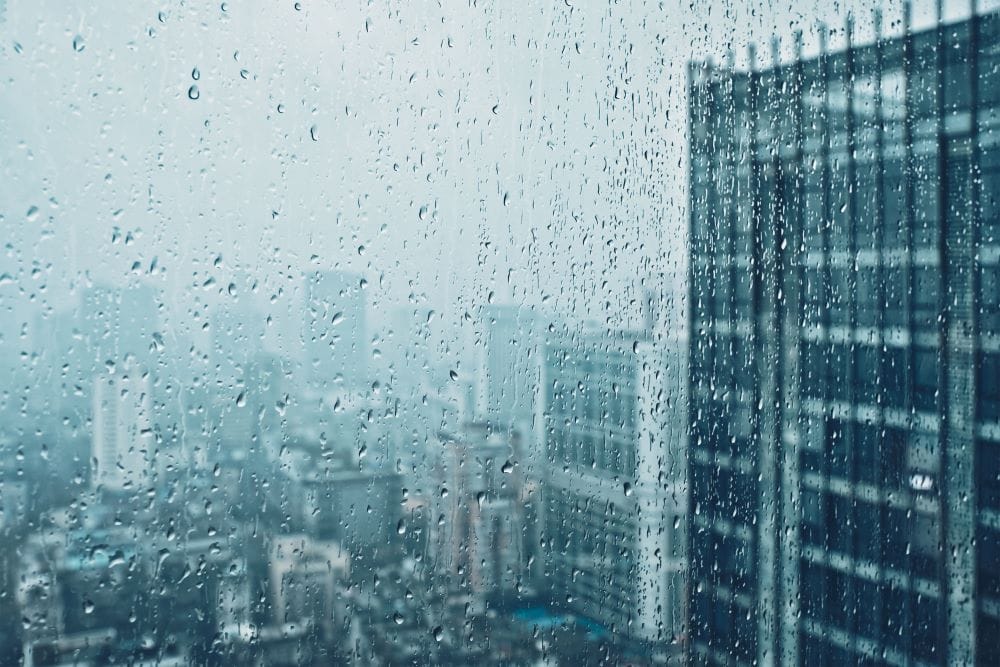 rain drops on window with city view