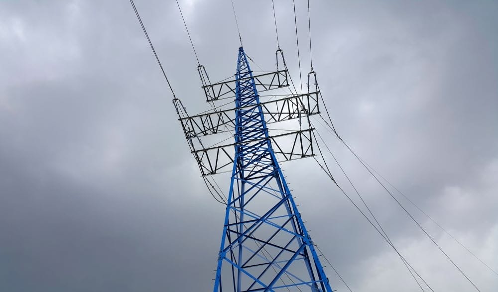 Electrical tower with clouds behind it