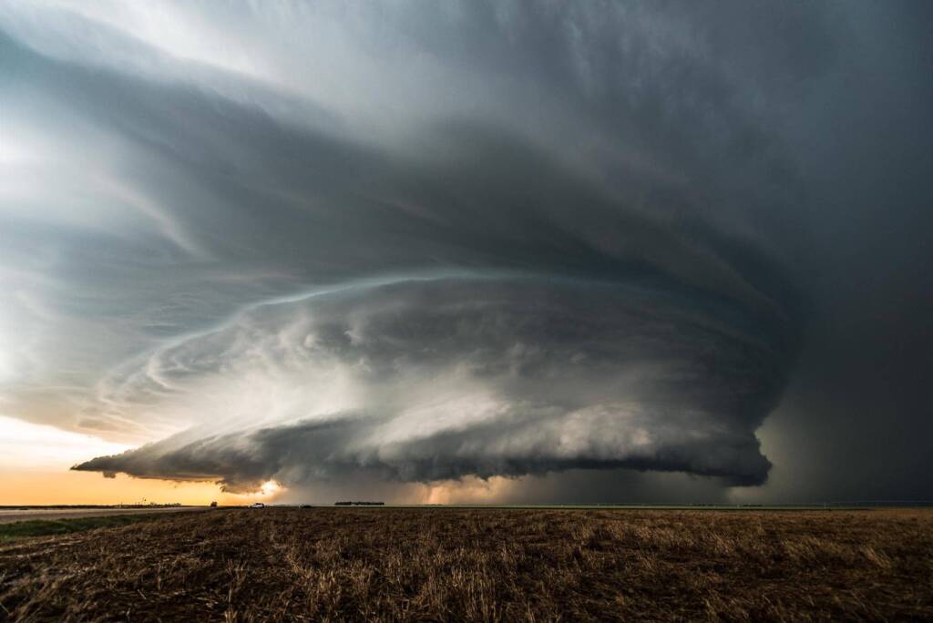 Large storm clouds hovering over an open field