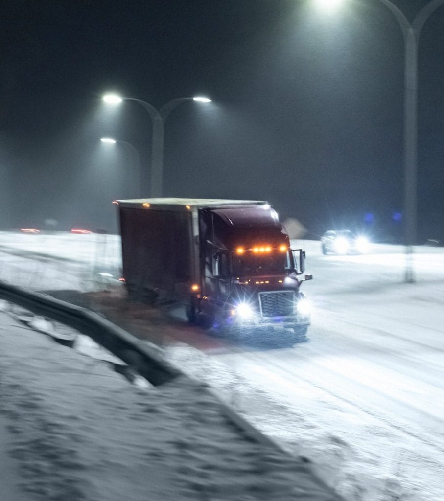 Truck driving on snowy roads at night